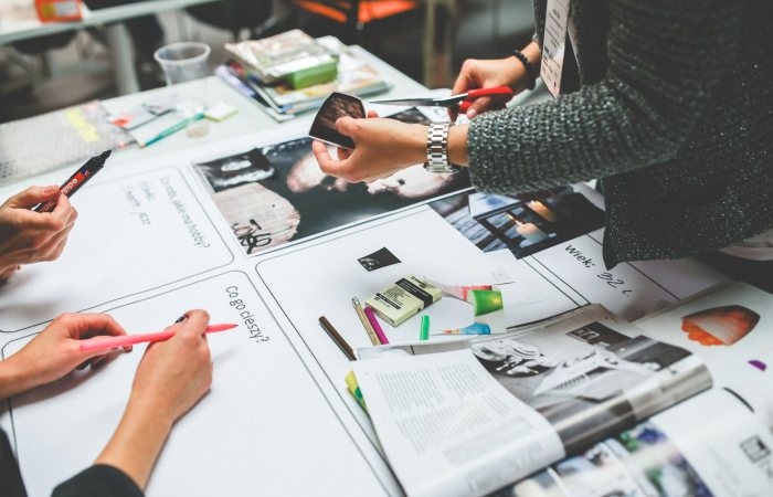 Team members brainstorming and collaborating on a design project in a modern office setting.