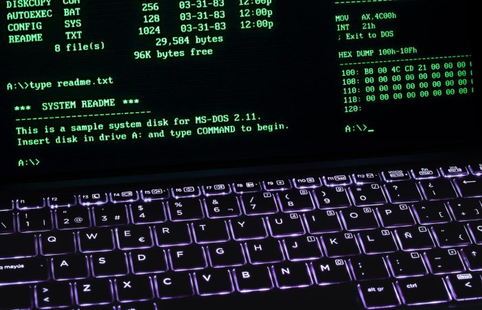 A classic MS-DOS terminal screen displayed on a laptop keyboard with vivid illumination.
