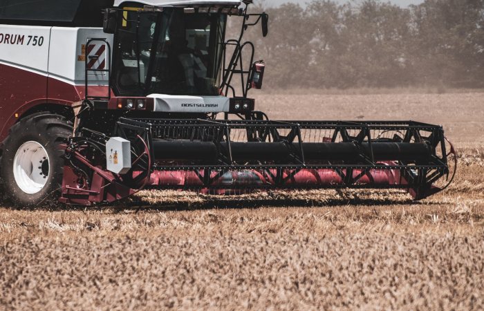 Combine harvester working in a wheat field during daytime, showcasing modern agricultural machinery.
