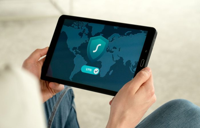 Person holding tablet with VPN connection screen for secure internet browsing.