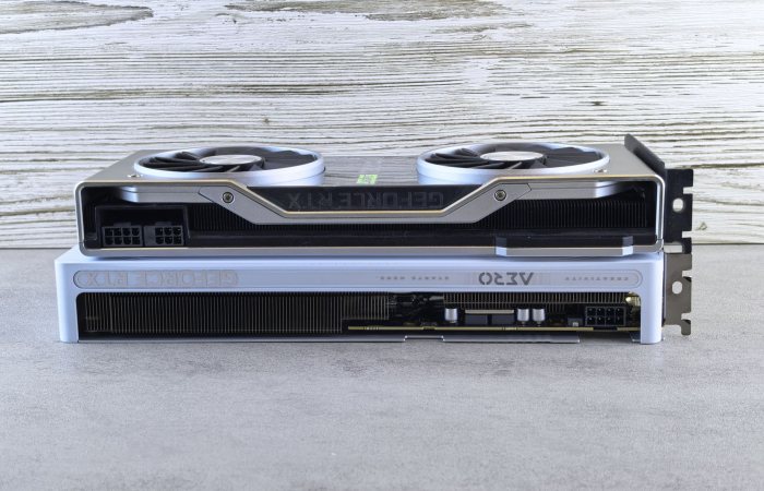 Two modern graphics cards stacked on a wooden surface, showcasing sleek design and advanced technology.